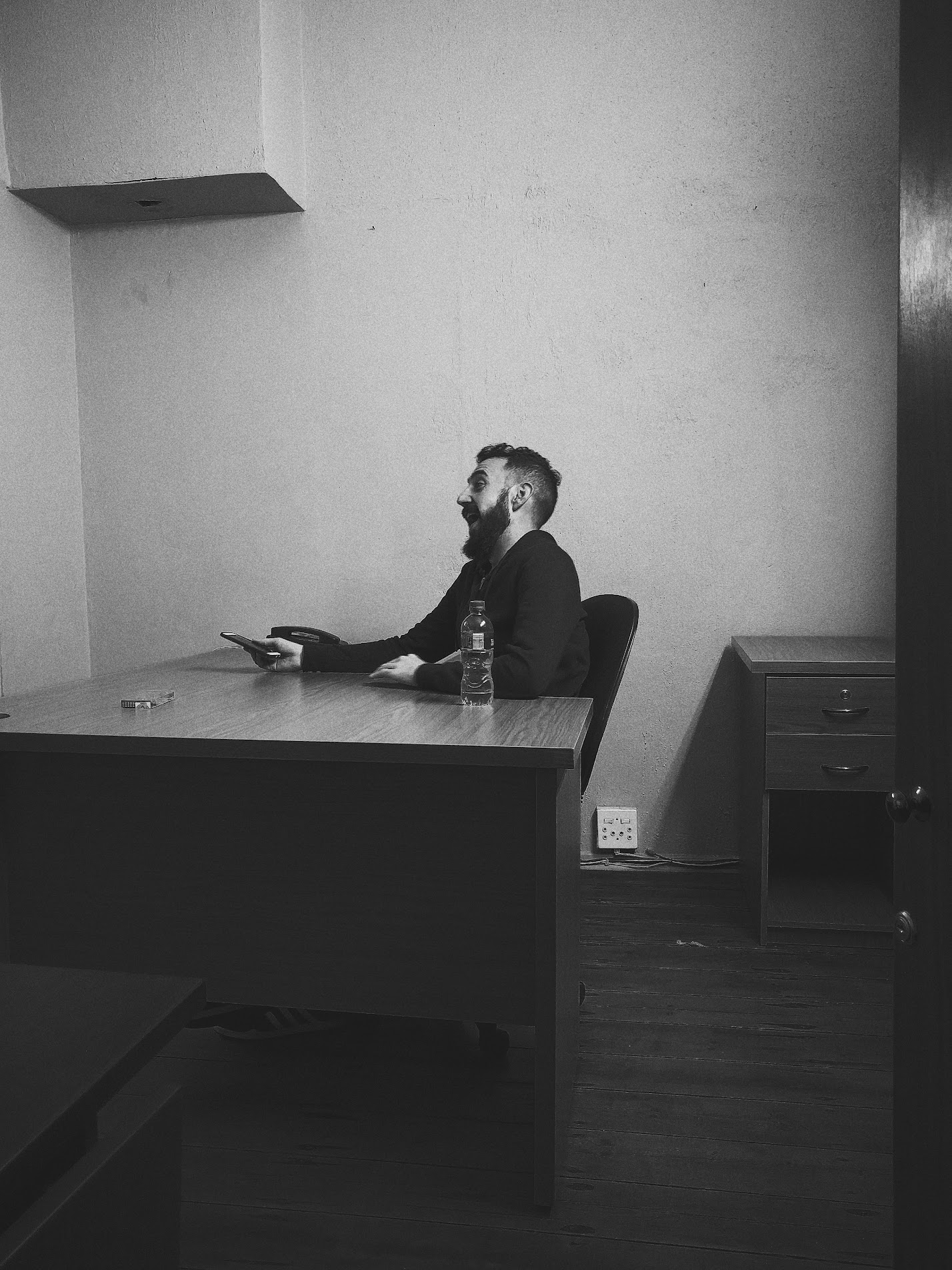 Photograph of Founder Brett laughing at his desk in the Doris Street COBB office in 2016. Photograph by Mohit Sooka